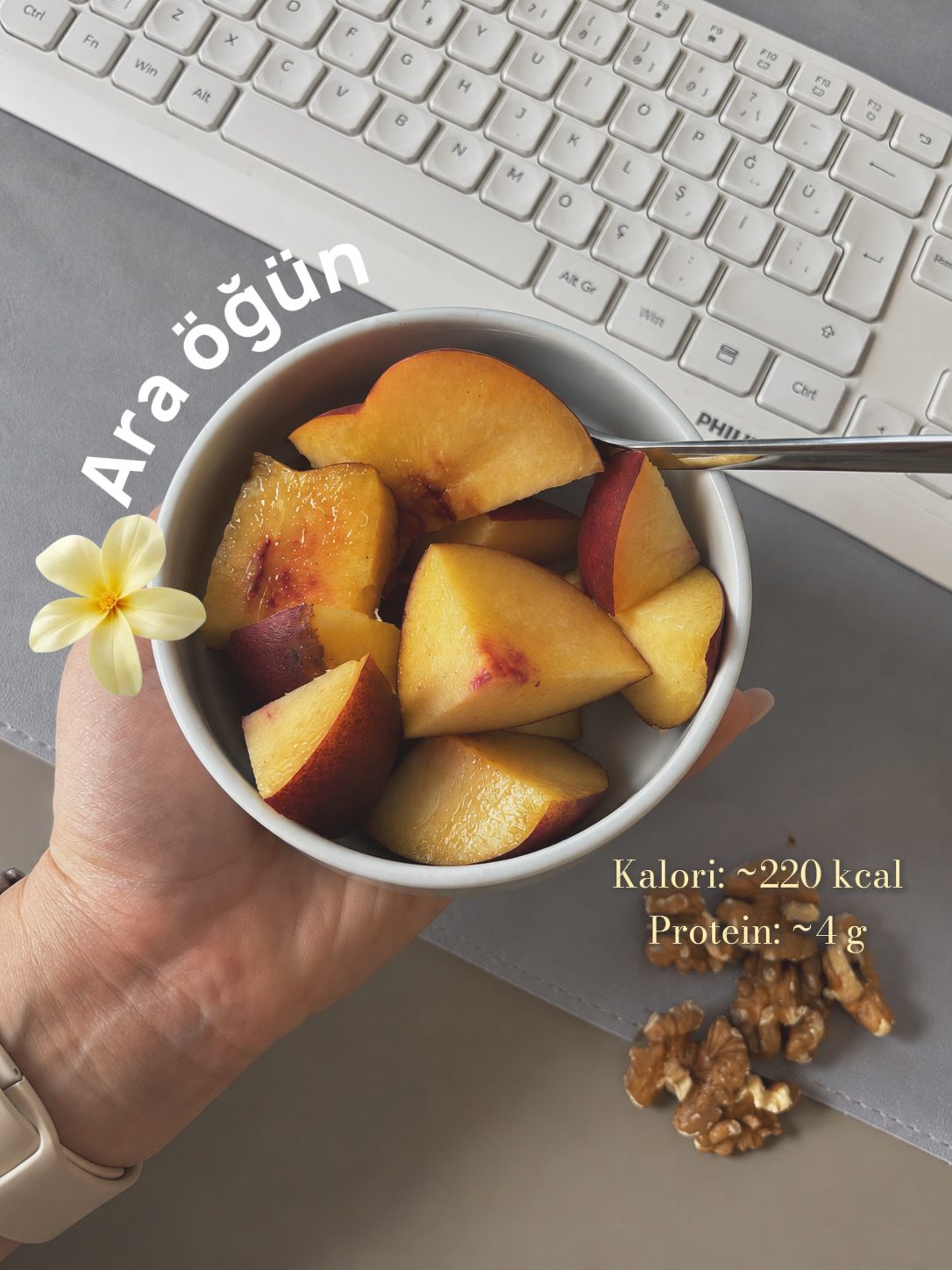 Dilimlenmiş meyve ve cevizle ilk ara öğün; görselde yaklaşık 220 kcal ve 4 g protein notu.